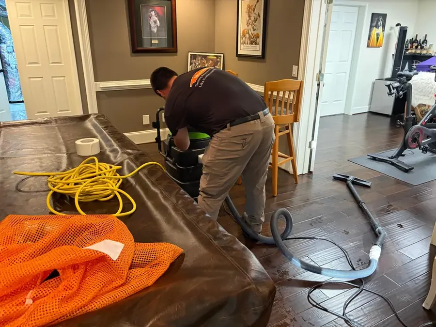 A crew member working a water-damaged room in a Yucaipa, CA home